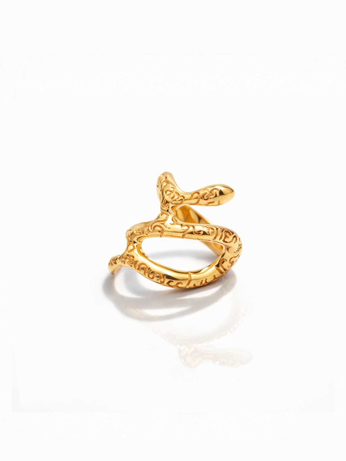 Gold ring with intricate design on a white background