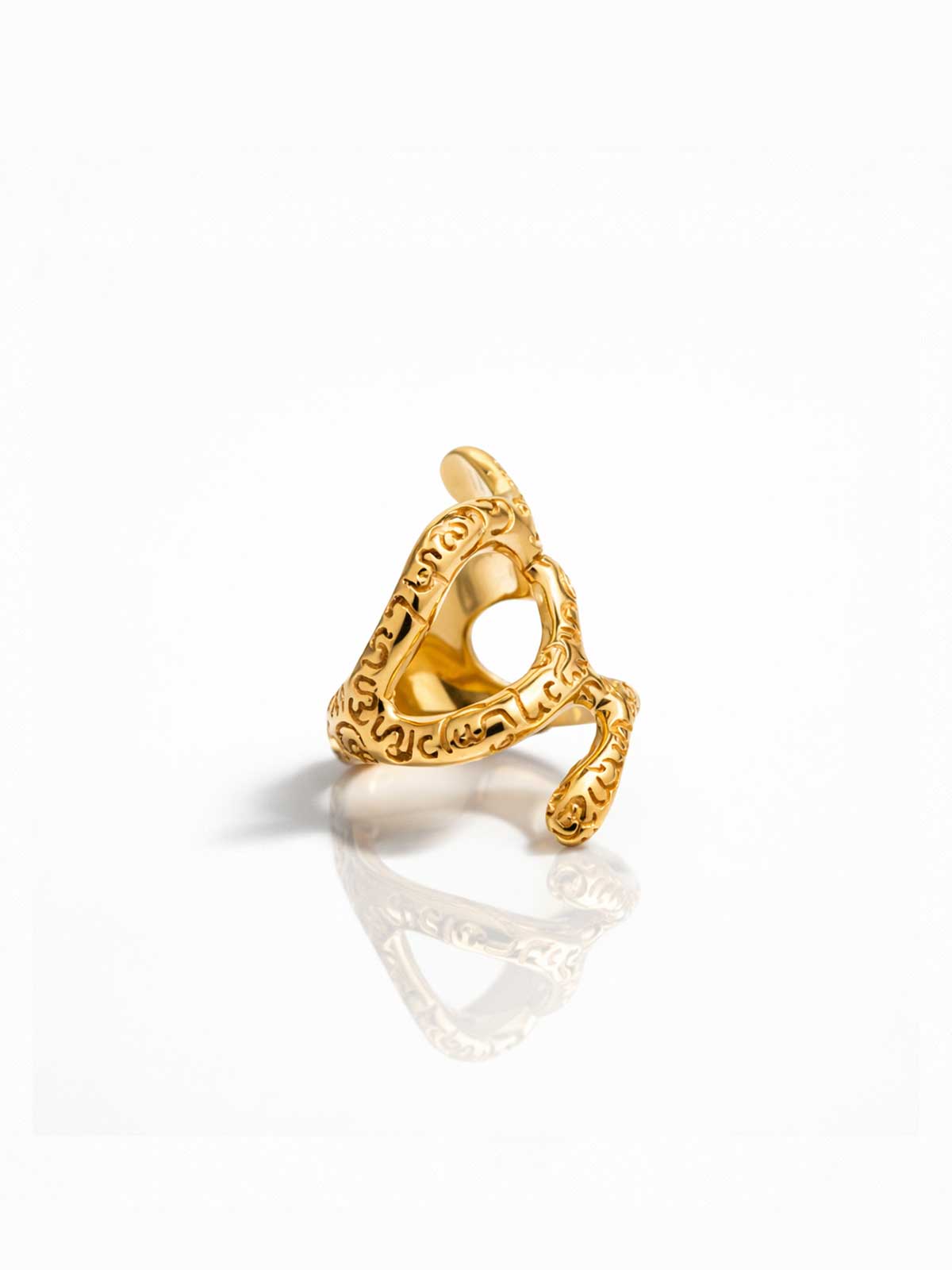 Gold ring with intricate design on a white background