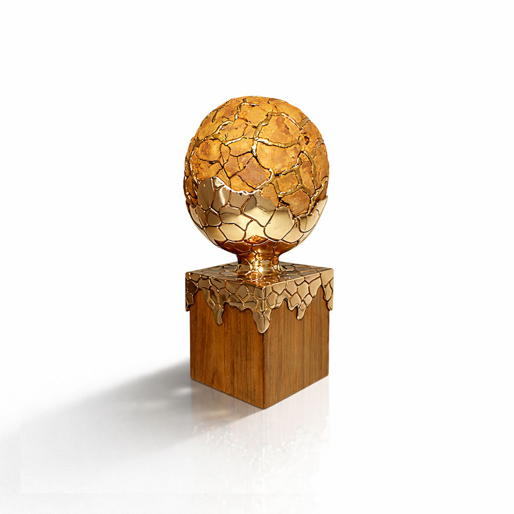Decorative object with gold spherical top and wooden base on a white background