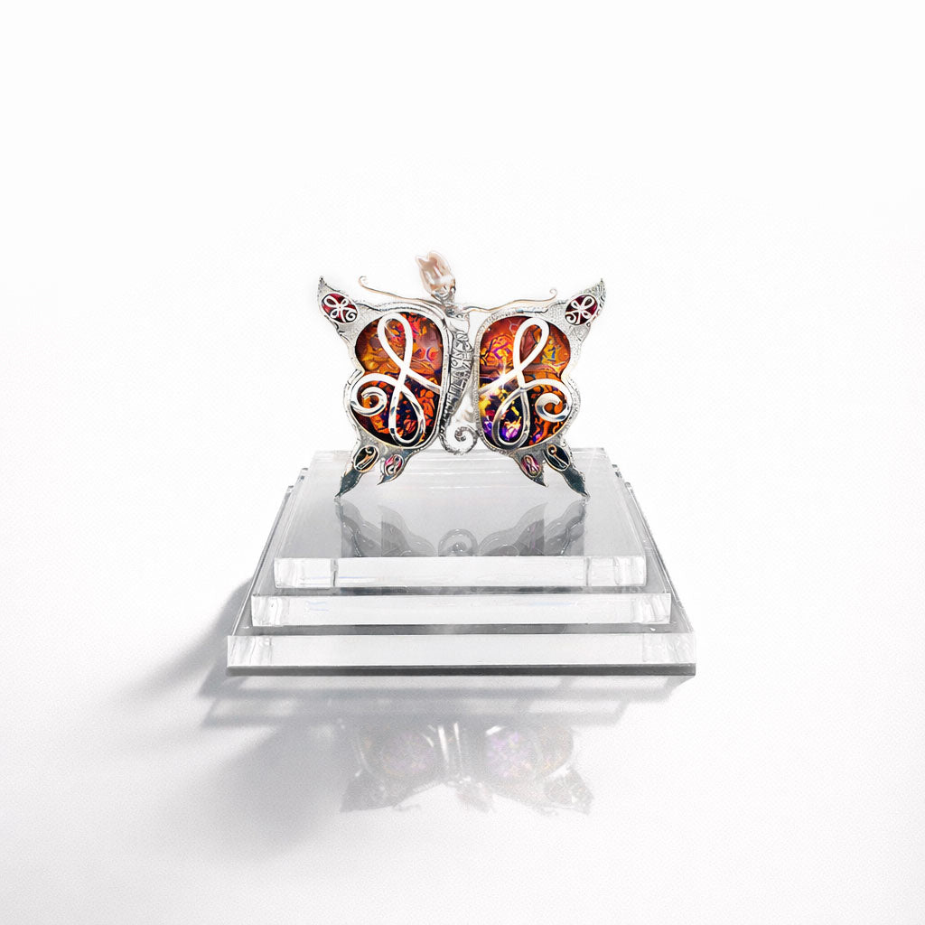 Butterfly-shaped jewelry on a clear stand with a white background