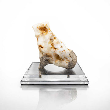 Decorative rock on a reflective platform against a white background